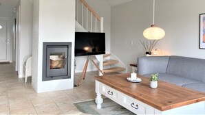 A modern living room with a fireplace, a television, a sofa, and a wooden coffee table. - "Eike" - 250m from the sea by Interhome (Brenderup Fyn)