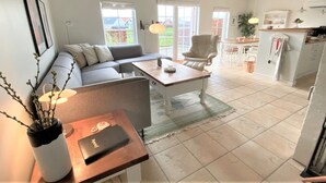 A modern living space with a sofa, a dining table, a chair, and a kitchen area. - "Eike" - 250m from the sea by Interhome (Brenderup Fyn)