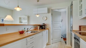 A modern kitchen with white cabinetry, a wooden countertop, and pendant lighting. - "Eike" - 250m from the sea by Interhome (Brenderup Fyn)