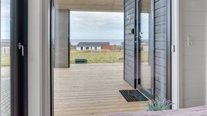 A modern home with a wooden deck, a sliding glass door, and a view of the sea. - "Gunborg" - 400m from the sea by Interhome (Sjølund)