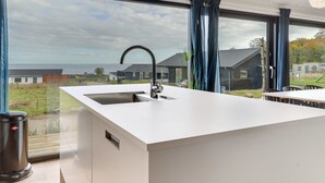 A modern kitchen with a large island, a built-in sink, and a view of the surrounding neighborhood. - "Gunborg" - 400m from the sea by Interhome (Sjølund)