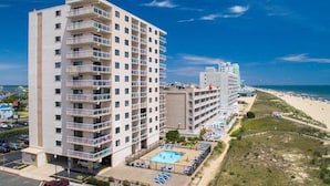 Een hotel met meerdere verdiepingen, zwembad, toegang tot het strand en uitzicht op de oceaan.