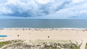 Een strand met een zandstrand, een hek en een heldere lucht.