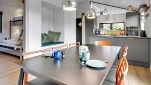 A modern kitchen with a dining area, wooden furniture, and pendant lighting. - "Sinna" -  from the sea by Interhome (Hals)