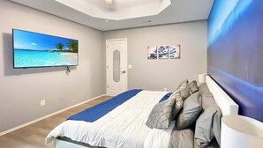 A modern bedroom with a bed, a TV, and artwork on the walls. - The Stay at Steuben, Fire Pit, Brand new furniture (Springdale)