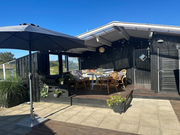 Relax and dine al fresco in this outdoor patio area, featuring a round table and wicker chairs.