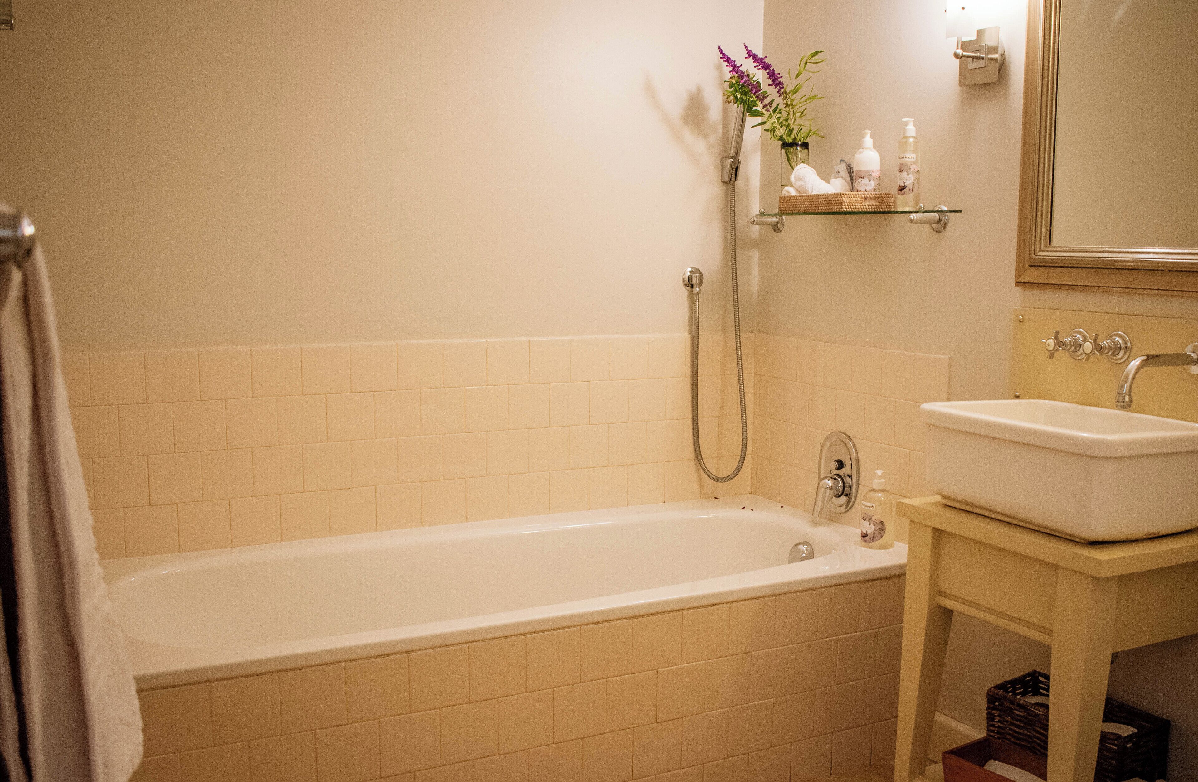 A bathroom with a bathtub, a sink, and a mirror.