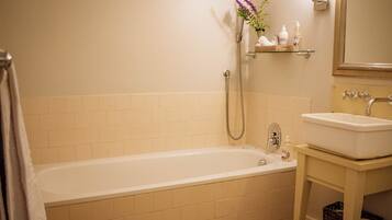 A bathroom with a bathtub, a sink, and a mirror.