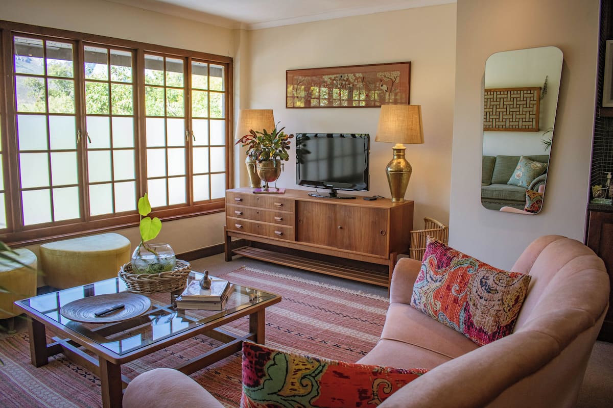 A living room with a television, wooden cabinet, and a sofa.