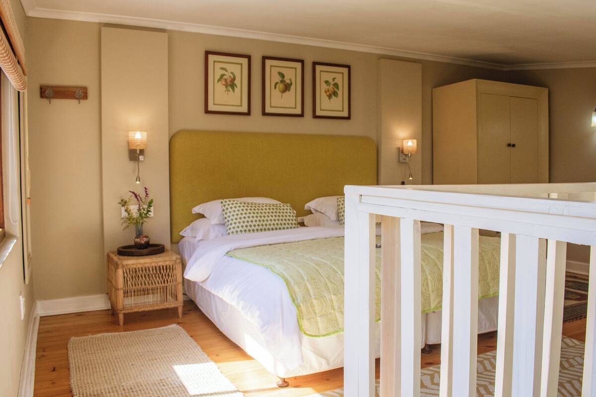 A bedroom with a bed, bedside tables, a wardrobe, and wall-mounted lights.