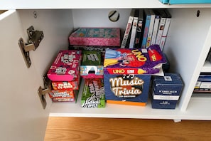 A shelf with various board games and trivia books. - Carlenes Getaway | Lake Views, Beach & Games Hub (Loch Sport)
