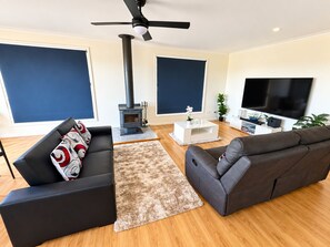 A modern living room with a fireplace, two sofas, a coffee table, and a TV.