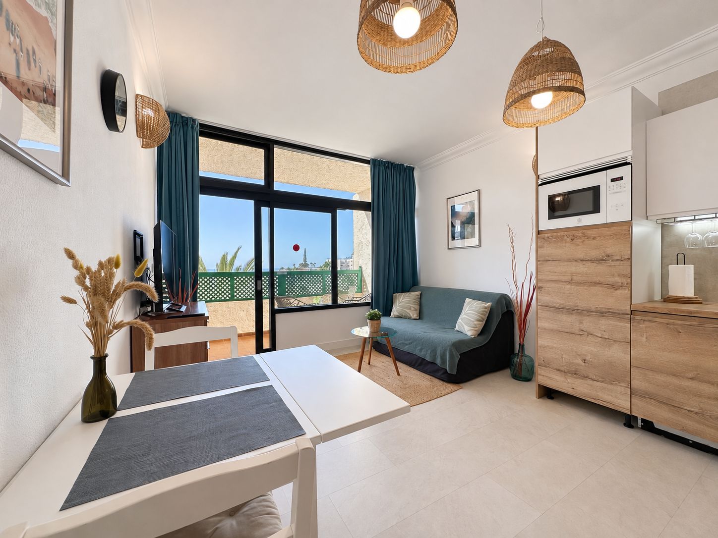 Ein modernes Wohnzimmer mit Sofa, Esstisch und Küchenbereich.