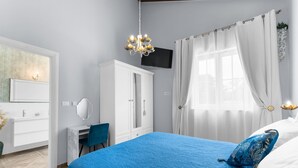 A bedroom with a large bed, a desk, a chair, a TV, and a window with curtains. - Sienna Zminj in Krculi (Zminj)