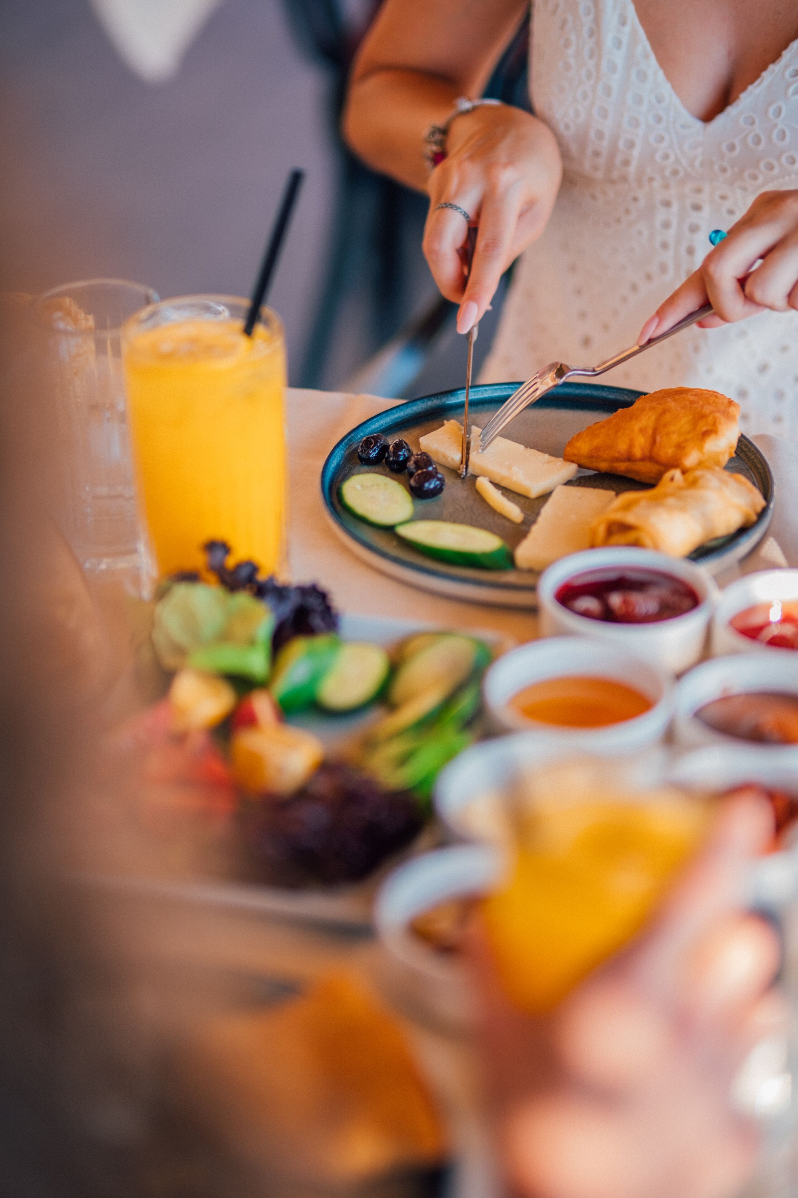 A breakfast setting with a plate of food, a glass of orange juice, and various condiments.
