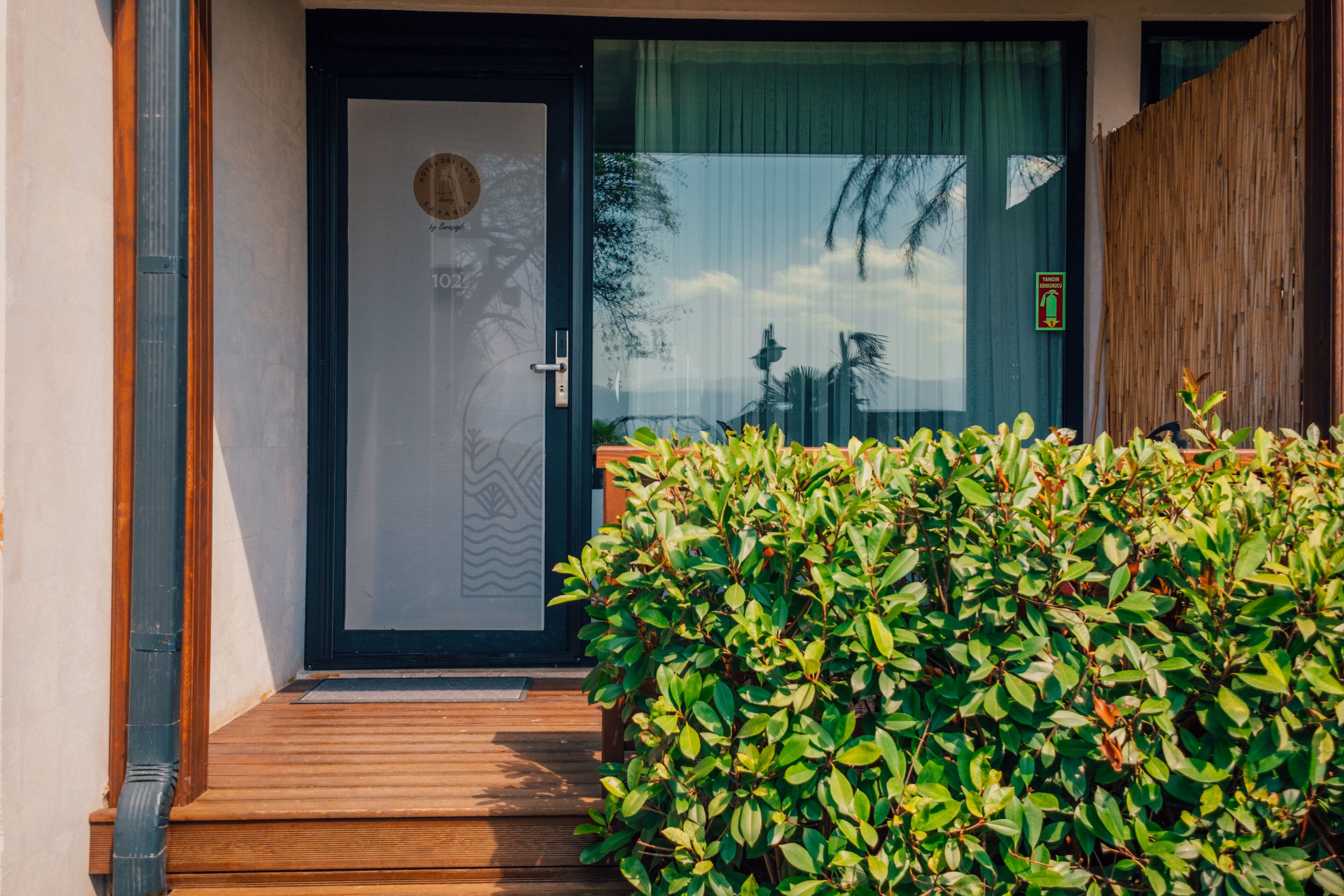 A wooden staircase leading to a door with a frosted glass panel and a circular logo.