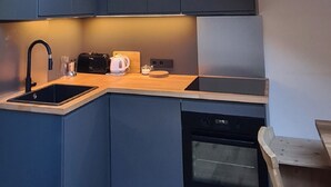 Una cucina compatta con finestra a soffitto, pensili e un piccolo forno.