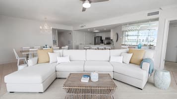 Una sala de estar moderna con un sofá modular, una mesa de centro y un comedor con sillas.