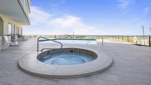 A hot tub surrounded by a pool, outdoor seating, and a view of the beach. - Epic 4BR/4BA Gulf Front | Free Beach Chair Service (Navarre)