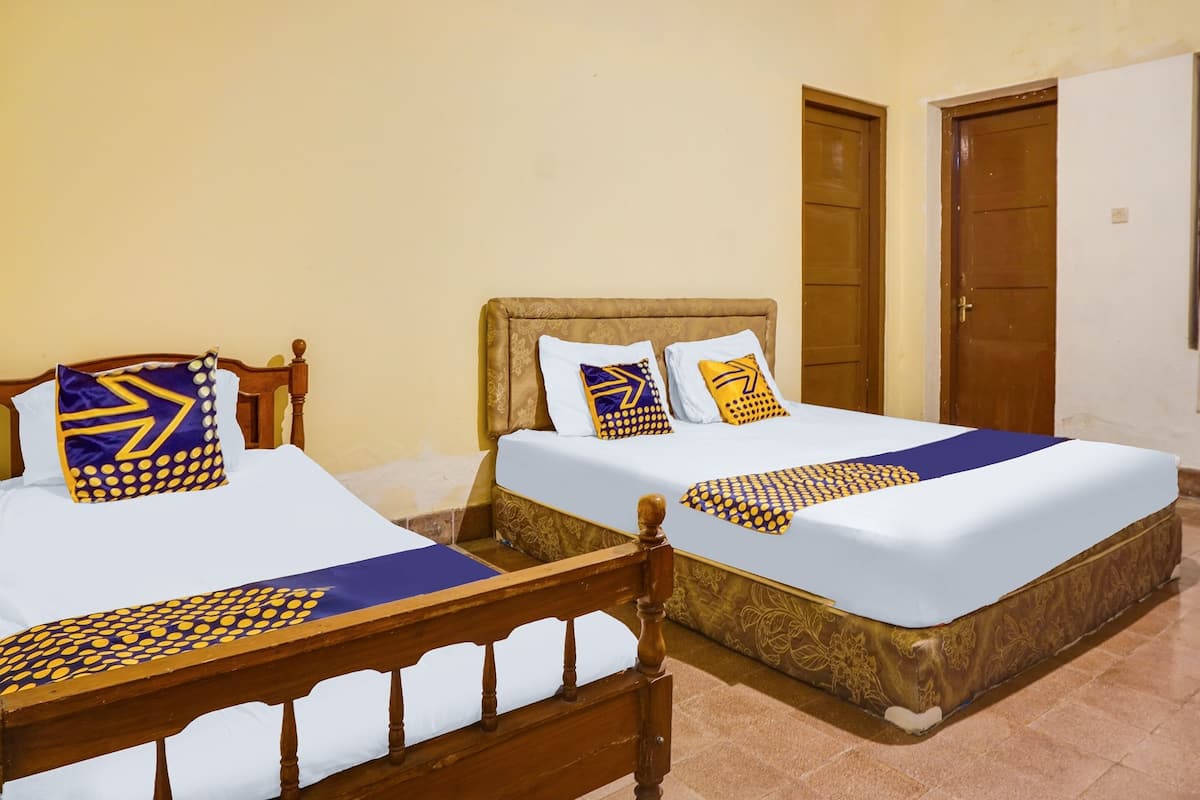 Two single beds with wooden frames and headboards, each with patterned bedding and pillows.