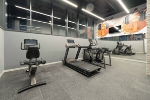Ein Fitnessstudio mit Laufbändern, Crosstrainern und Ergometer.