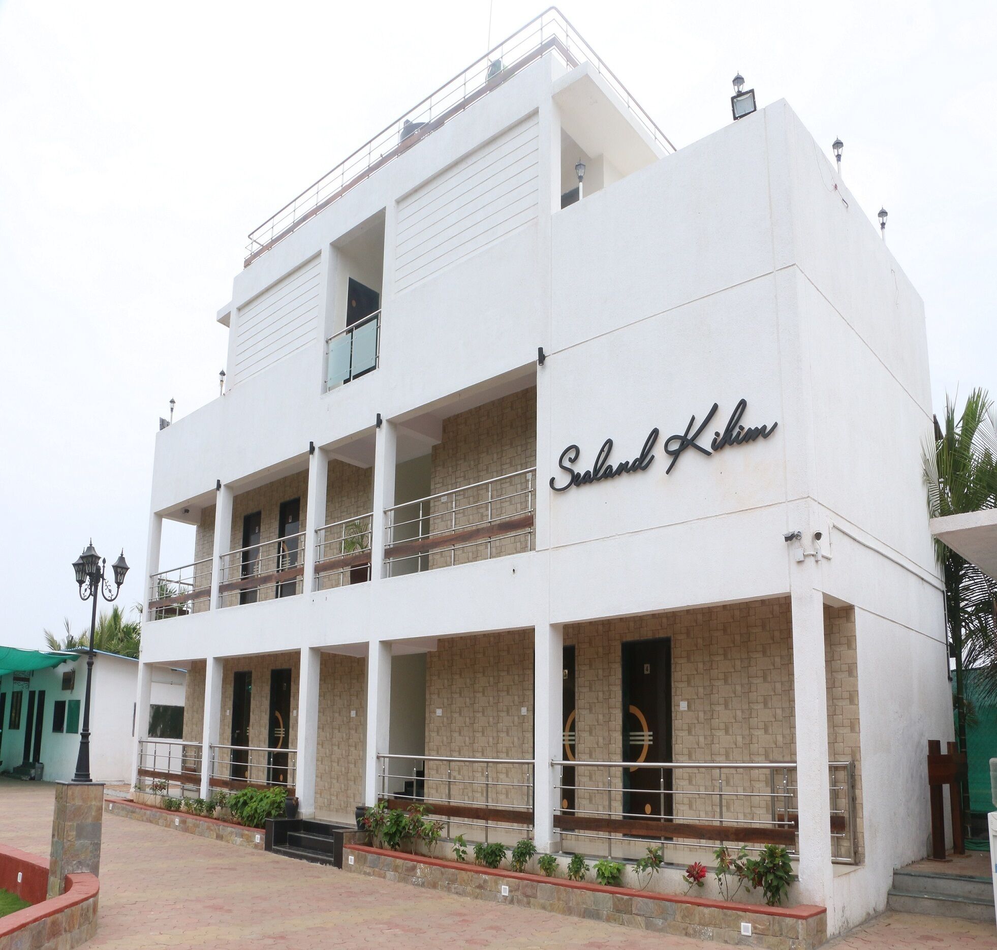 A two-story building with a sign reading "Sealand Kikim". It features a balcony on the upper floor and a series of windows on the ground floor.