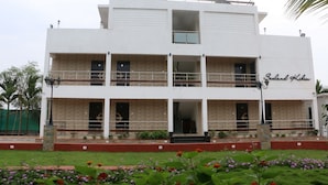 A two-story building with balconies and a sign that reads "Sealand Hotel". - Sealand Kihim (Alibag)