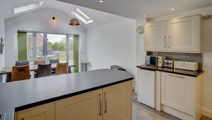 Une cuisine moderne dotée d’un îlot central, d’appareils électroménagers intégrés et d’un coin repas avec des chaises et une table.