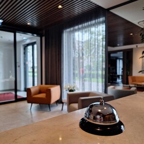 A modern lobby with a reception desk, seating area, and large windows. - Hotel iNova (Zagreb)