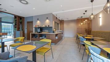 Um restaurante moderno com balcão central, diversas áreas de estar e iluminação pendente.