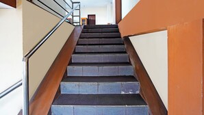 A staircase with metal railings and stone steps, leading to a door at the top. - OYO 91415 De Wijaya Hotel (Sidoarjo)