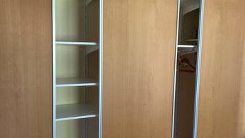 Un vestidor con varias puertas y estantes de madera.