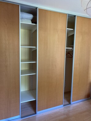 A walk-in closet with multiple wooden doors and shelves.
