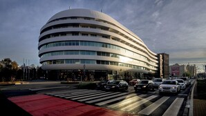 Ein modernes Gebäude mit einer geschwungenen Fassade und mehreren Stockwerken.