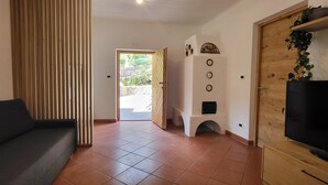 A living room with a sofa, a TV, and a fireplace. - Fruemess Superior (Partschins)