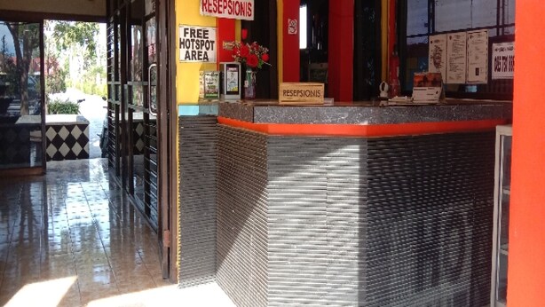 A reception area with a 'Free Hotspot Area' sign, a reception desk, and a 'Receptionis' sign. - Hotel O Mutiara (Ponorogo)