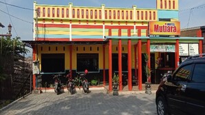 A colorful hotel with a sign reading "HOTEL Mutiyana." - Hotel O Mutiara (Ponorogo)