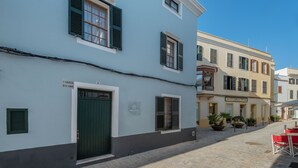 A street view of a building with a green door and shutters, a sign reading "CARRER DAL MORO", and a cobblestone street. - Hotel Tres Tocs (Ciutadella de Menorca)