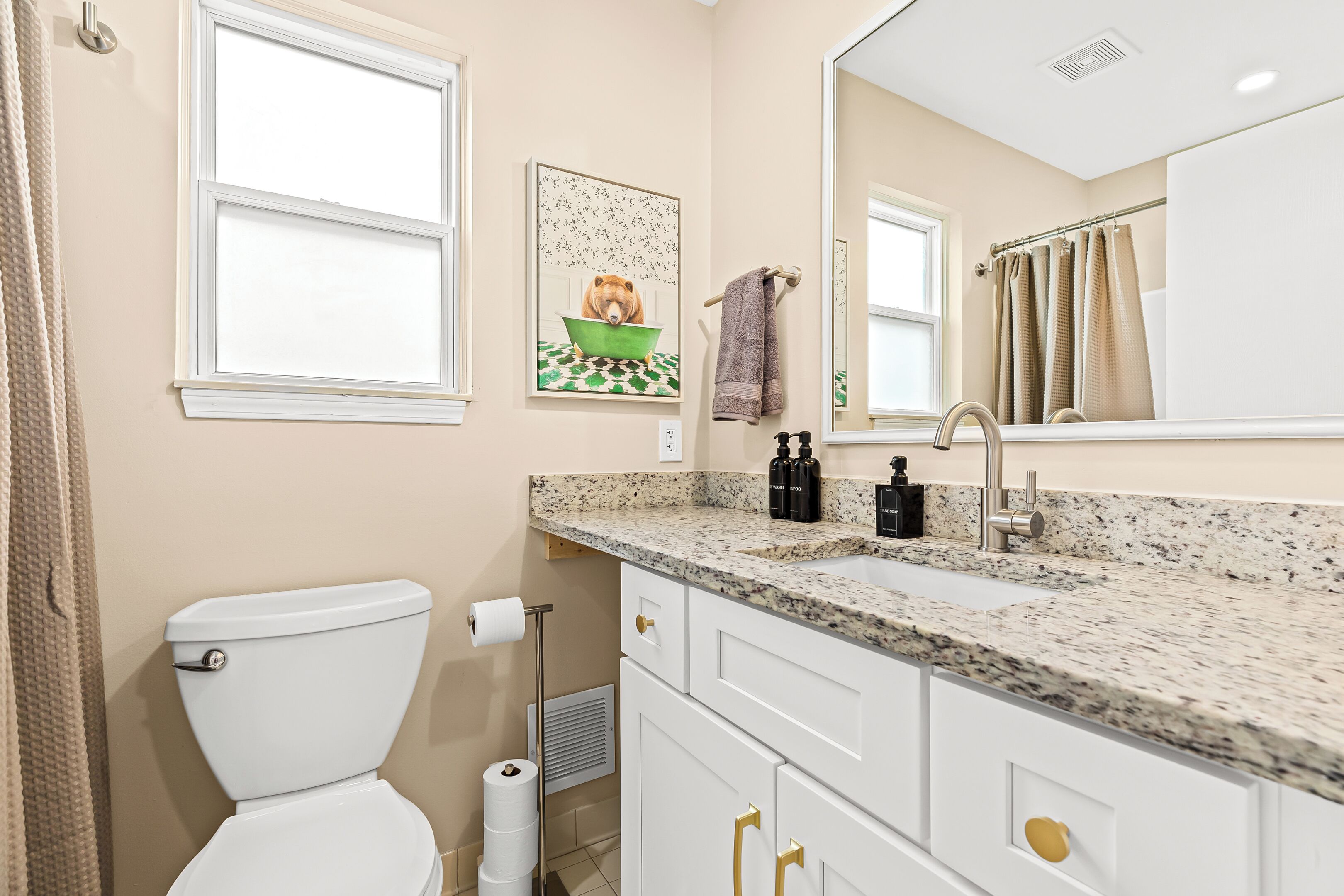Une salle de bain avec des toilettes, un lavabo et un miroir.