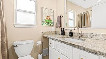 Une salle de bain avec des toilettes, un lavabo et un miroir.