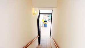 A staircase with wooden handrails leading to an open doorway.
