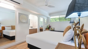 A modern hotel room with a large bed, a desk, and a bathroom. - Whitsunday Apartment West 1302 (Hamilton Island)