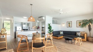A modern living room with a round table, two chairs, a sofa, and a coffee table. - Whitsunday Apartment West 1302 (Hamilton Island)
