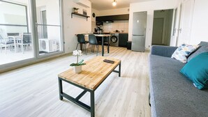 A modern apartment with a dining area, kitchen, and living room.