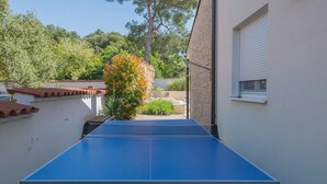 A ping pong table in a backyard with a white wall and a window. - Allegra Istriana in Fa ana (Fazana)