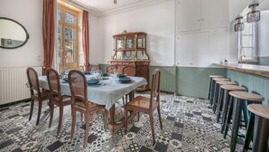 Un comedor con una mesa dispuesta para seis personas, rodeada de sillas, un aparador de madera y un suelo con diseño.