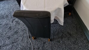 Una sala conferenze con un tavolo bianco, sedie nere e pavimento rivestito di moquette.
