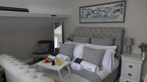 A neatly arranged bedroom with a bed, bedside tables, a chair, and a small table with breakfast items. - 3 Bedroom Cottage in the heart of Conwy | Parking | Sleeps 4 (Conwy)