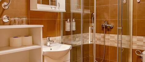 A modern bathroom with a glass-enclosed shower, a white vanity with a sink, and a toilet.