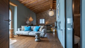 A spacious living room with a high ceiling, a stone wall, and a large window. - Riecine Capanna  4, Gaiole in Chianti, Siena and Chianti (Gaiole in Chianti)